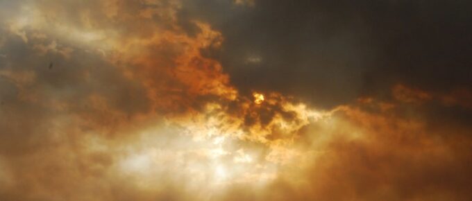 amber-sky-sun-peaking-through-clouds