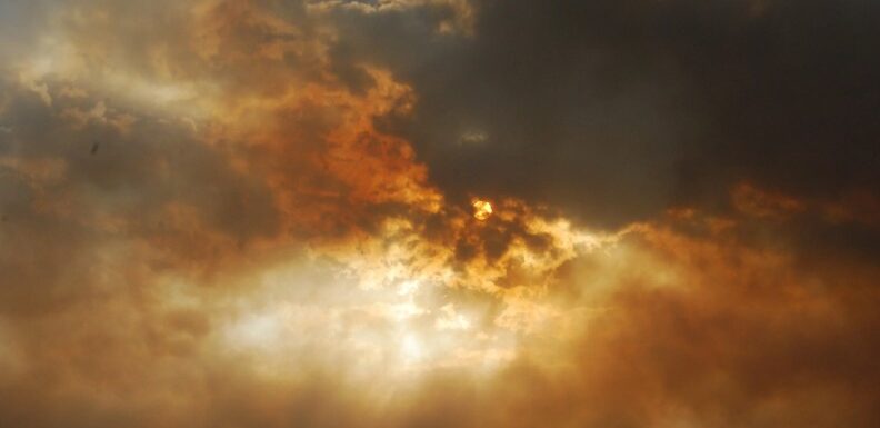 amber-sky-sun-peaking-through-clouds